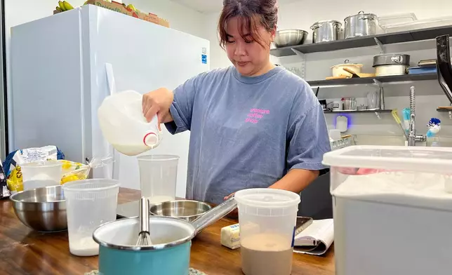 Pastry chef Amanda Tabadero pours milk into a plastic container while preparing ingredients for maritozzi at Creature Coffeeshop in Kaneʻohe, Hawaii, Tuesday, July 7, 2026. (Hikari Mae Hida/Honolulu Civil Beat via AP)