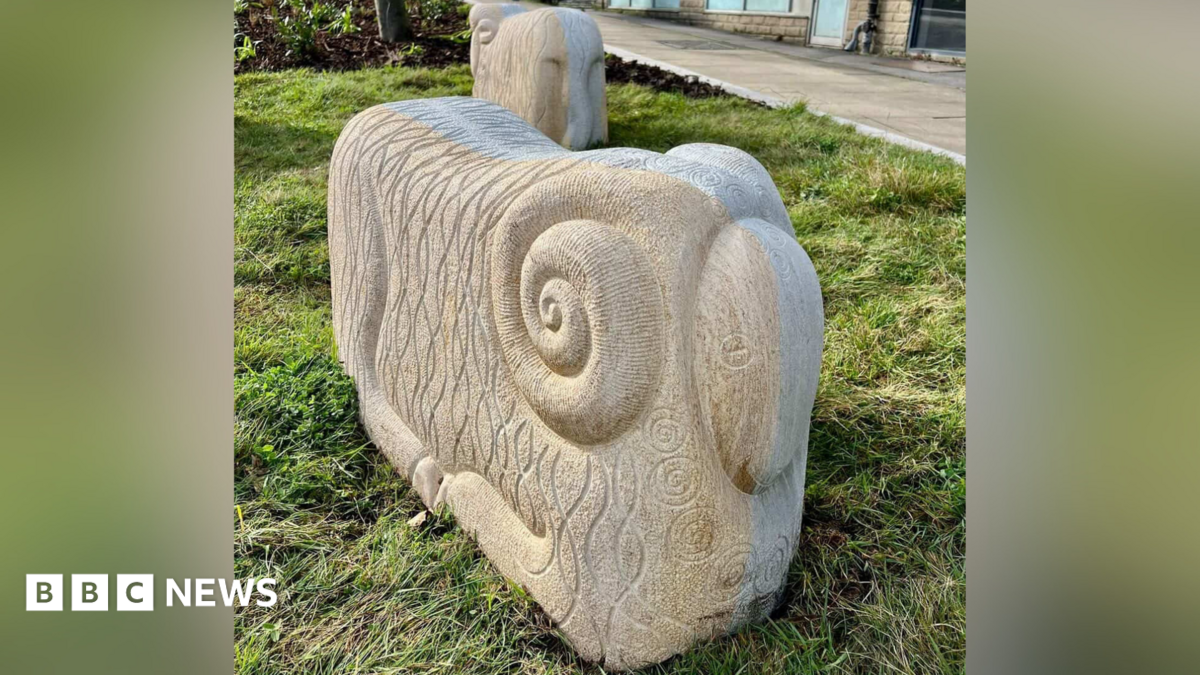 A stone sheep. It is a cuboid shape with rounded edges. It has curled horns on the side.