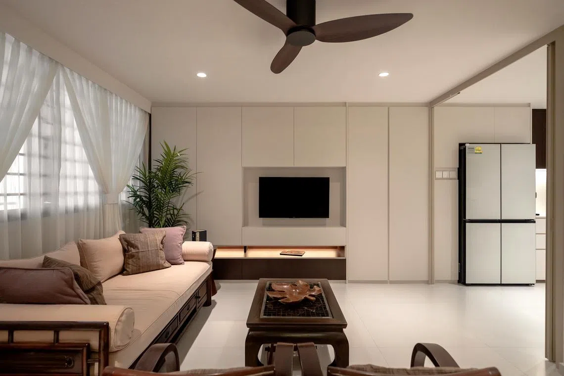 Semi-sheer white curtains let light into the living room while protecting the owner’s privacy.