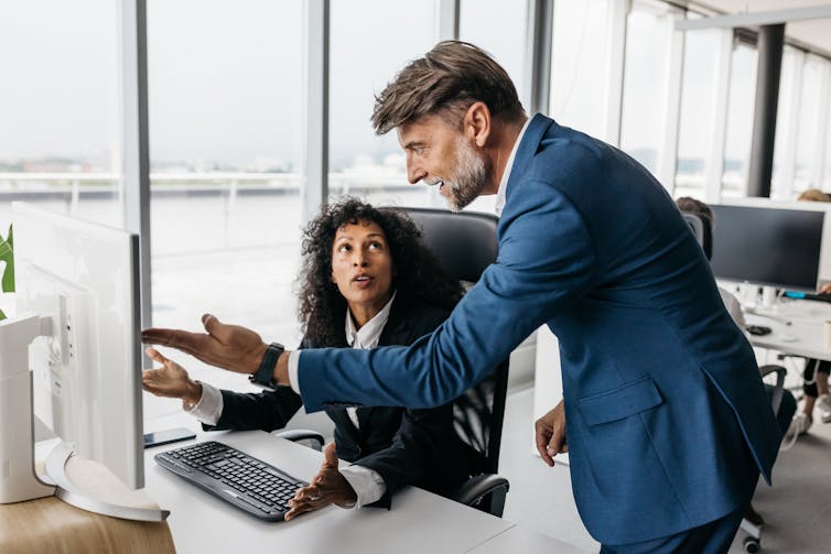 A smartly dressed business woman and businessman are having a heated discussion.