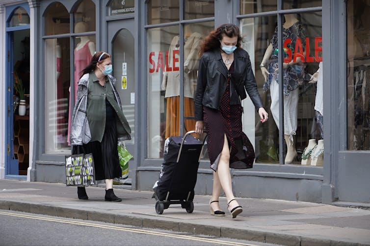 Women walking while wearing face masks.