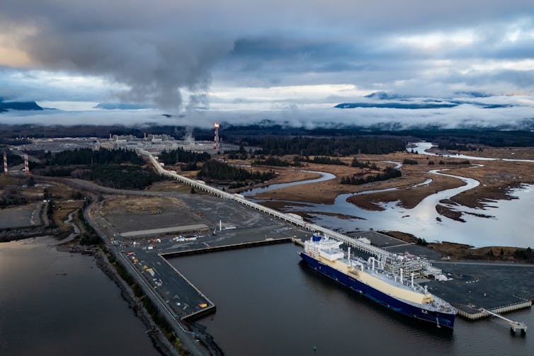 an aerial view of a fuel tanker on the water near an industrial plant