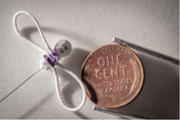 A penny compared to a tiny tracker that's not much later than the letter O in 'One Cent'