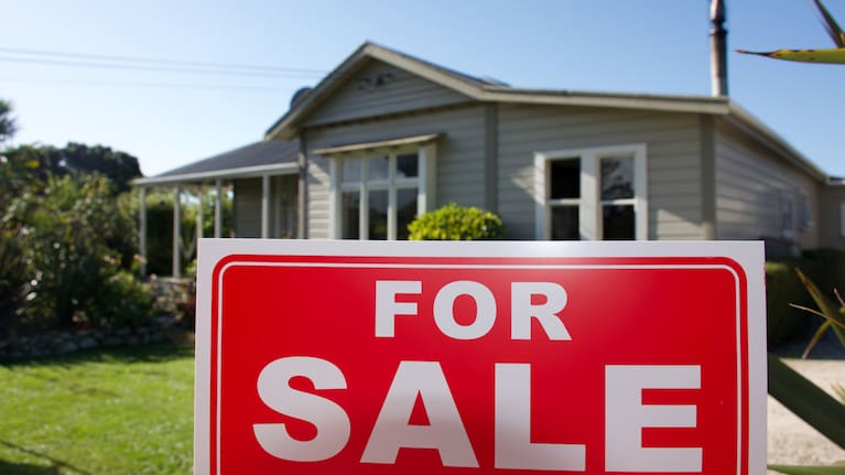 A for sale sign outside a house.