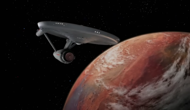a starship flying past an orange planet