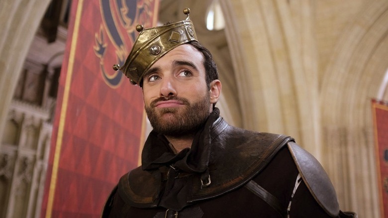 Galavant standing in a hallway adorned with flags