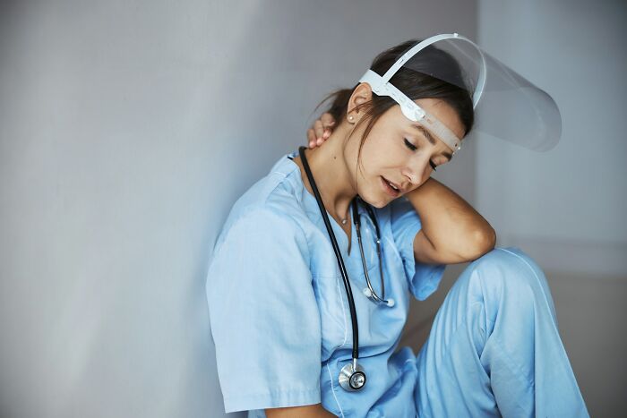 ER staff are exhausted by ridiculous patients; a female doctor in scrubs sits with her head down.