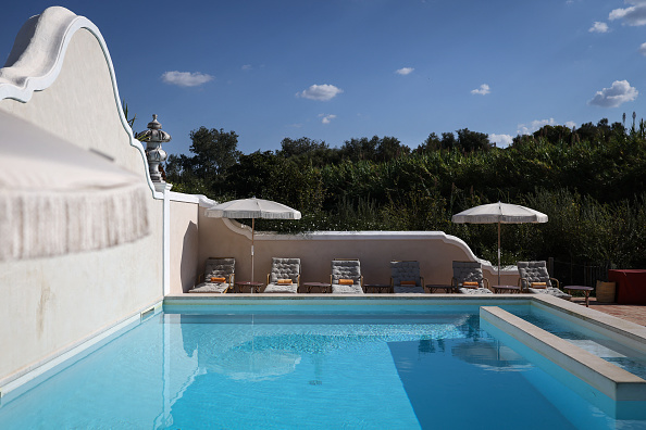 This picture taken on October 17, 2025 shows a view of the pool at "Vermelho" hotel, owned by French designer Christian Louboutin, one of the first international figures to discover the region, in Melides, southwestern Portugal. Above the pine forests and dunes stretching along the nearly deserted beaches of southwestern Portugal, cranes rise from luxury hotel projects, a sign of the region's transformation into a new playground for the rich. The coastal region of Comporta has attracted high-profile visitors, earning the nickname "the new Portuguese Riviera" and drawing comparisons to New York's elite Hamptons. (Photo by Patricia DE MELO MOREIRA / AFP) (Photo by PATRICIA DE MELO MOREIRA/AFP via Getty Images)