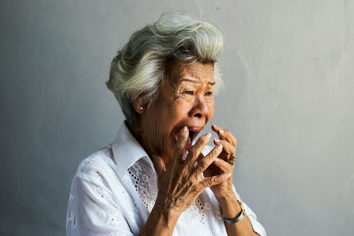 An elderly woman with a horrified expression, depicting the fear in hospital employees' horror stories.