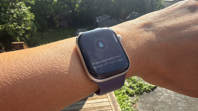 A wrist outside with an Apple Watch showing the water lock feature on.