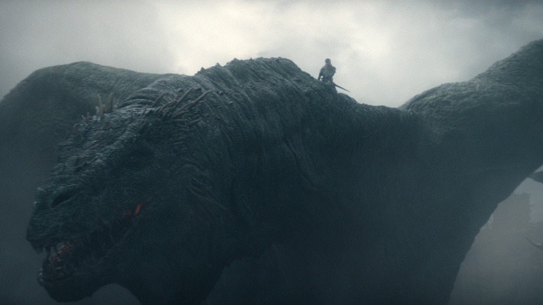 Ewan Mitchell as Aemond Targaryen riding on the back of a massive dragon in a cloudy sky in House of the Dragon