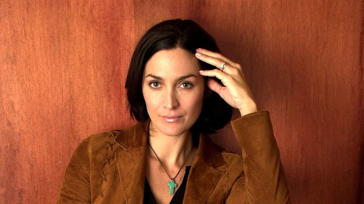 The Matrix star, 58, is unrecognizable as she seduces Heated Rivalry's Hudson Williams in new trailer
