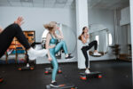 Women are doing high knees in an exercise class.