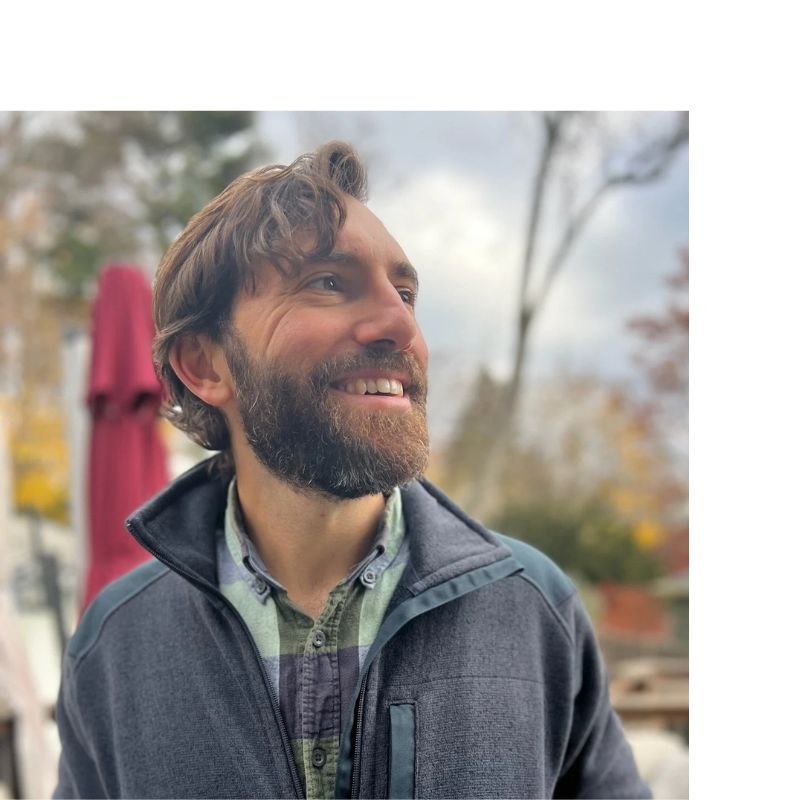 man faces to the side, smiling for a headshot photo