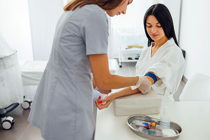 A nurse preparing a patient for a blood test, illustrating medical symptoms detection.