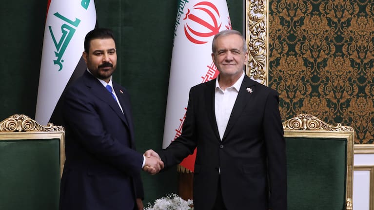In this photo released by the Iranian Presidency Office, President Masoud Pezeshkian, right, shakes hands with Iraq's Prime Minister Ali al-Zaidi during their meeting in Tehran, Iran`.