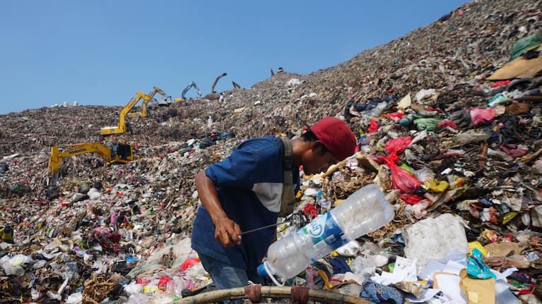 Waste pickers look for recyclable items in a pile of garbage at the Bantargebang landfill.