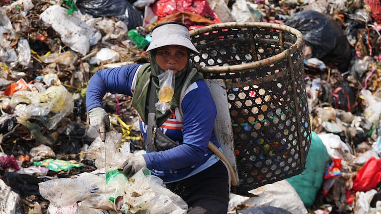 Waste pickers look for recyclable items in a pile of garbage at the Bantargebang landfill.