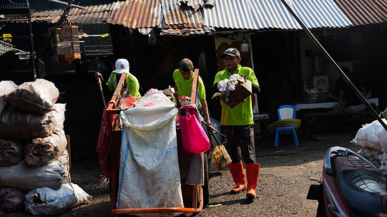 Sanitation workers collect trash at a traditional market in Jakarta.