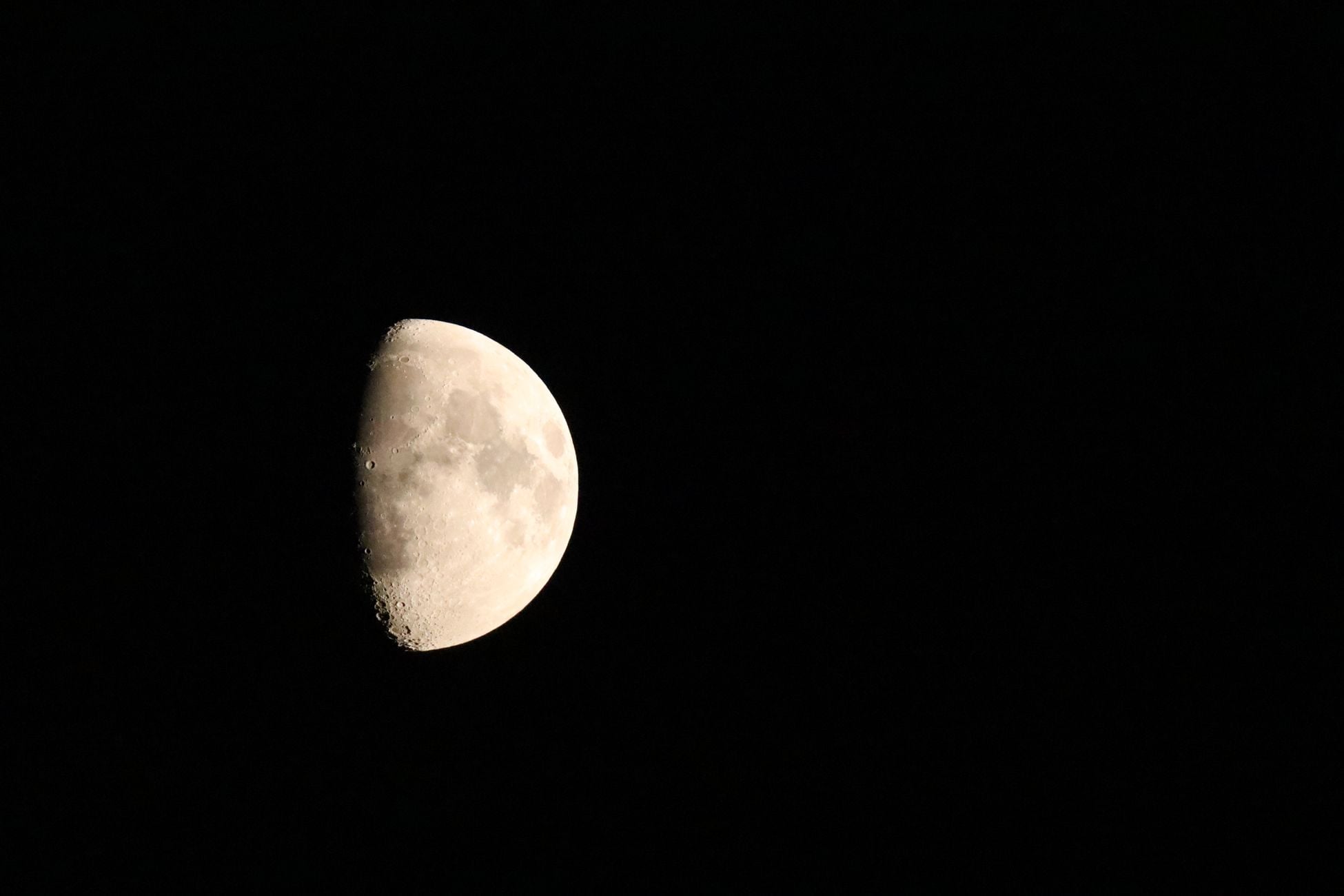 Captivating half moon against a deep, dark night sky, showcasing lunar detail.
