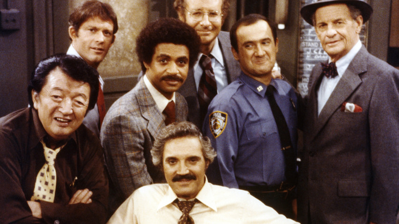 Hal Linden (seated, front), as Captain Barney Miller, with the cast of 'Barney Miller', circa 1978. Other cast members are (left to right): Jack Soo, Max Gail, Ron Glass, Steve Landesberg, Ron Carey, and James Gregory