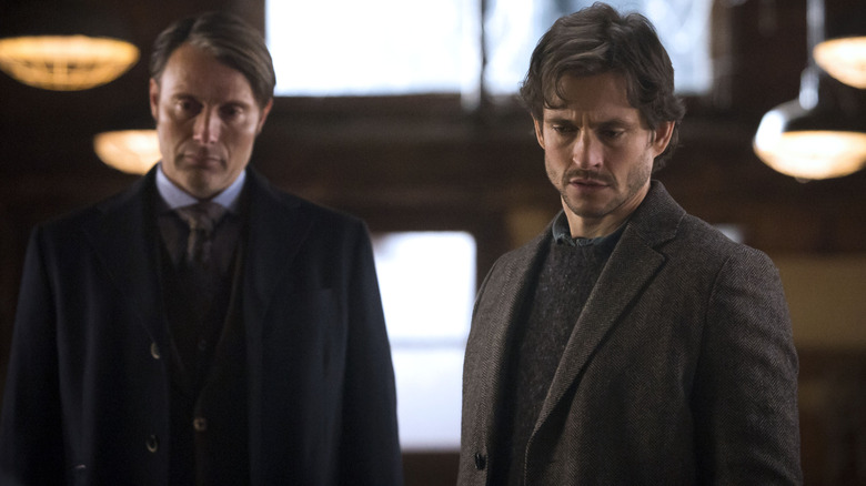 Dr. Hannibal Lecter (Mads Mikkelsen) and Will Graham (Hugh Dancy) standing together in Hannibal