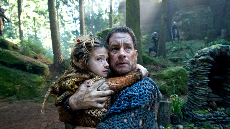 Zachry Bailey holding a young child in his hands in the woods