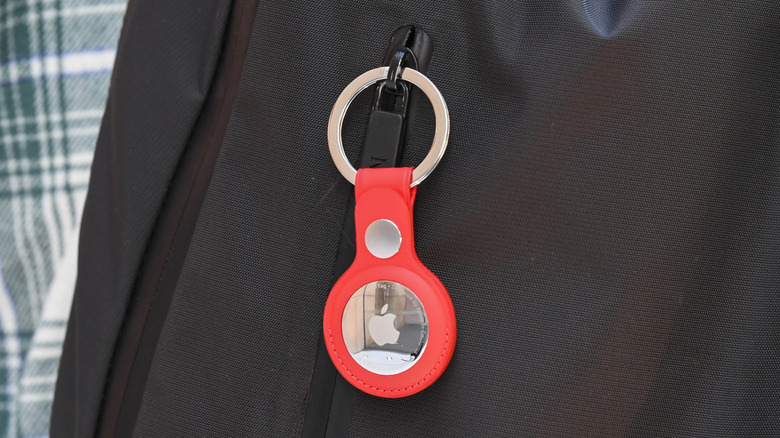 A key ring containing an AirTag attached to a rucksack