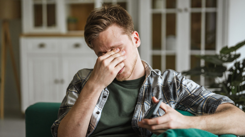 A man rubbing his eyes due to eye strain