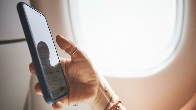 A person using a smartphone in an airplane.