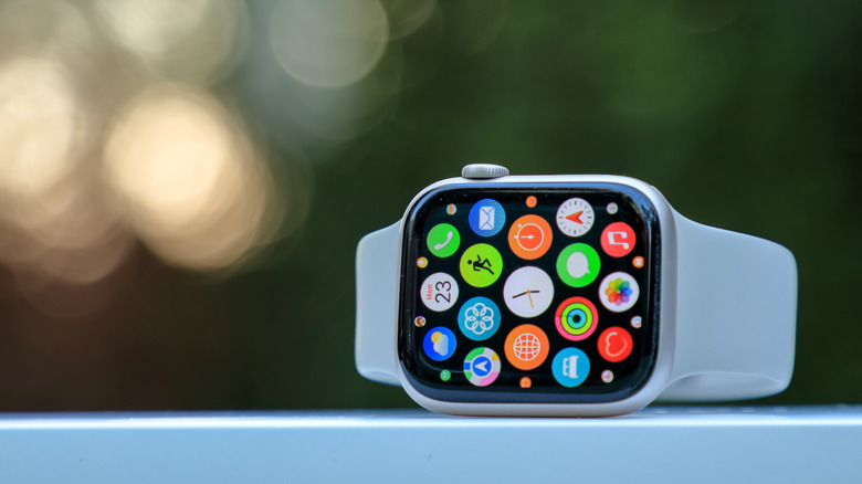 An Apple Watch on its side on a ledge outside.