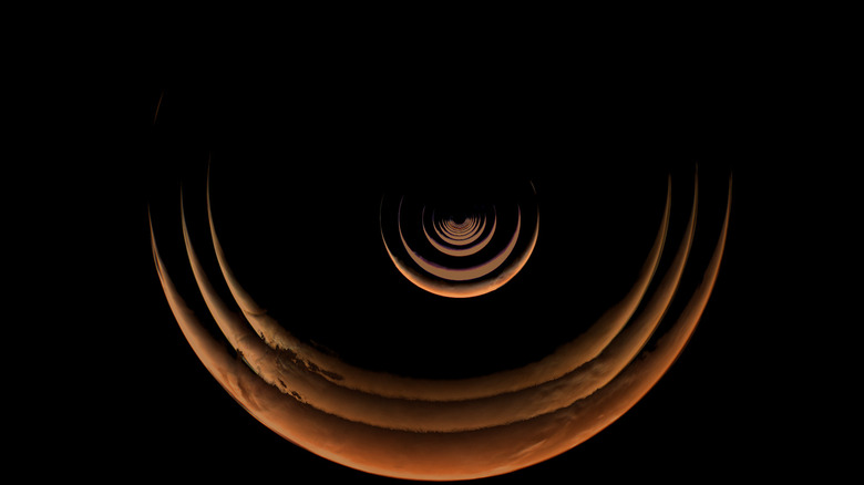 A composite of images taken by the Psyche spacecraft that shows views of the crescent Mars taken as the craft approached, stacked together