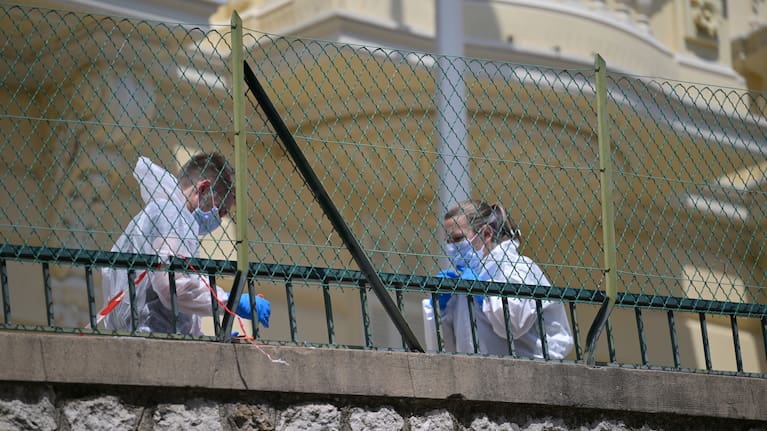 Investigators examine the scene at the residential building where an explosive device seriously injured three people a day earlier in Monaco, Tuesday, June 30, 2026.