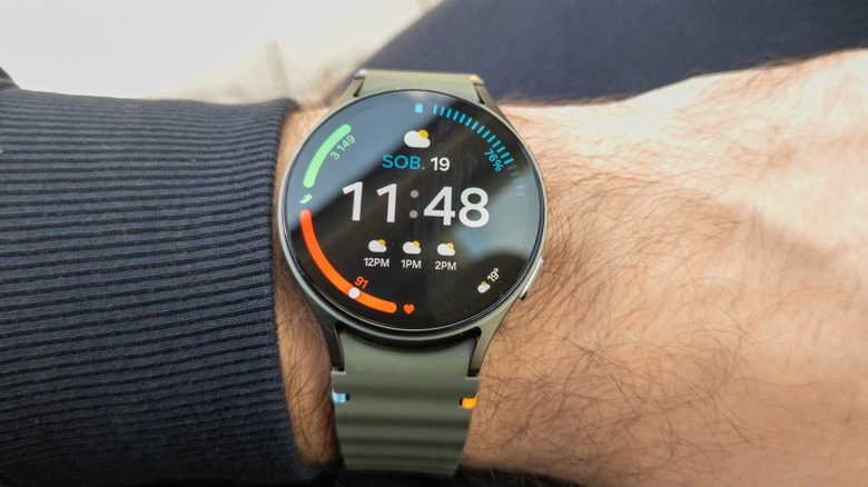 Person wearing a Samsung Galaxy Watch showing home screen