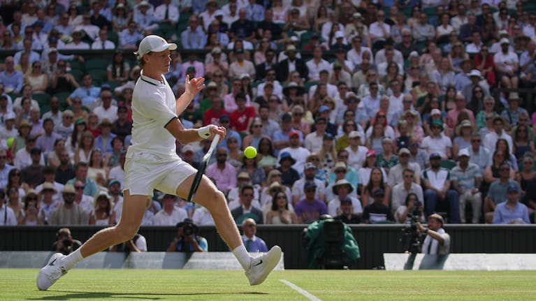 Jannik Sinner of Italy returns the ball to Novak Djokovic of Serbia