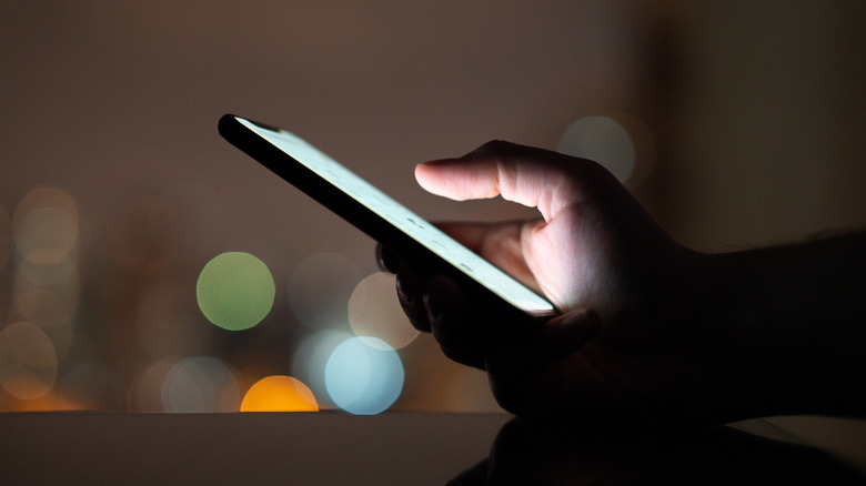 A person using a phone in the evening