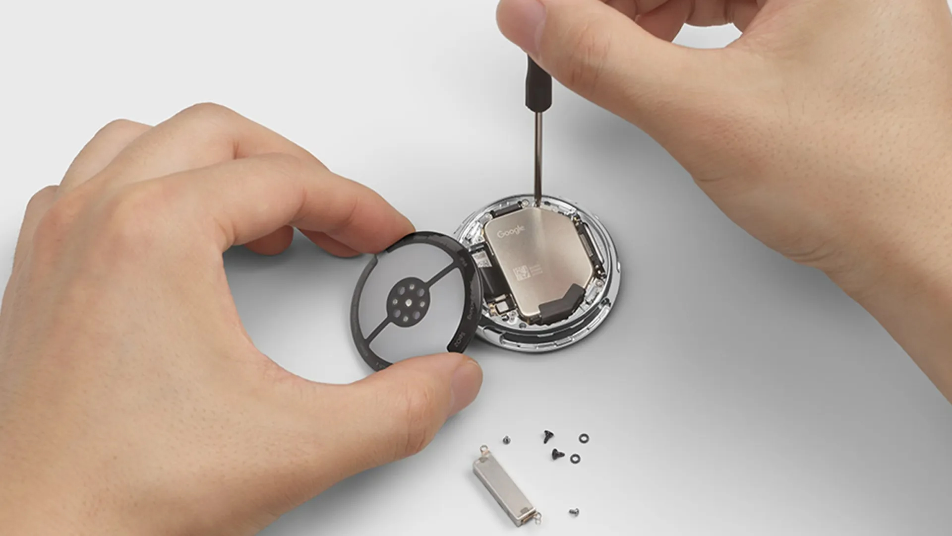 Two hands repairing a Google Pixel Watch 4