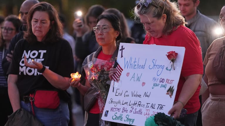 Michelle Whitehead, right, cousin of victim Ashley Whitehead, attends the vigil for victims the day after a shooting at Seattle Center during the Bite of Seattle food festival