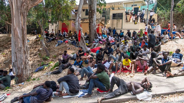 Migrants rest outside the Temporary Center for Immigrants (CETI) after crossing from Morocco into the Spanish enclave of Ceuta, Friday, July 31, 2026.