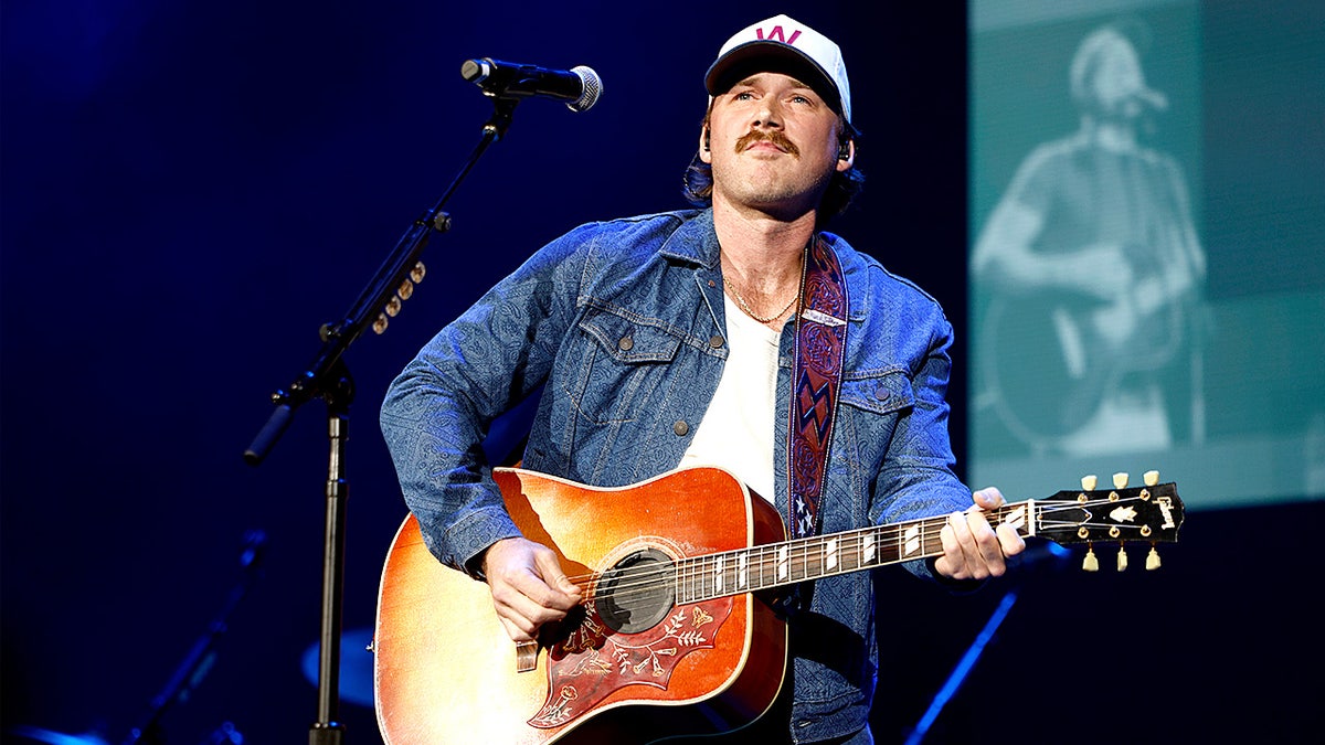 Morgan Wallen performs onstage at a benefit concert inside the Ryman Auditorium.