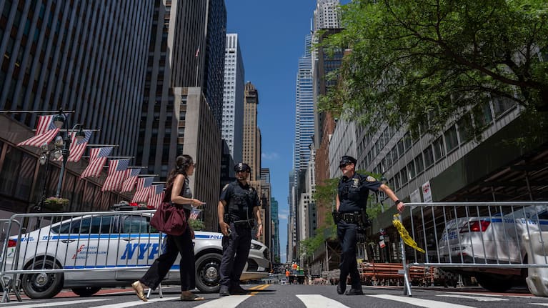 Police officers stand on the closed street near 235 East 42nd Street.