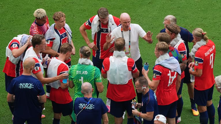 Norway head coach Stale Solbakken, in white shirt, talks to the team during a hydration break during the World Cup quarterfinal match between Norway and England.
