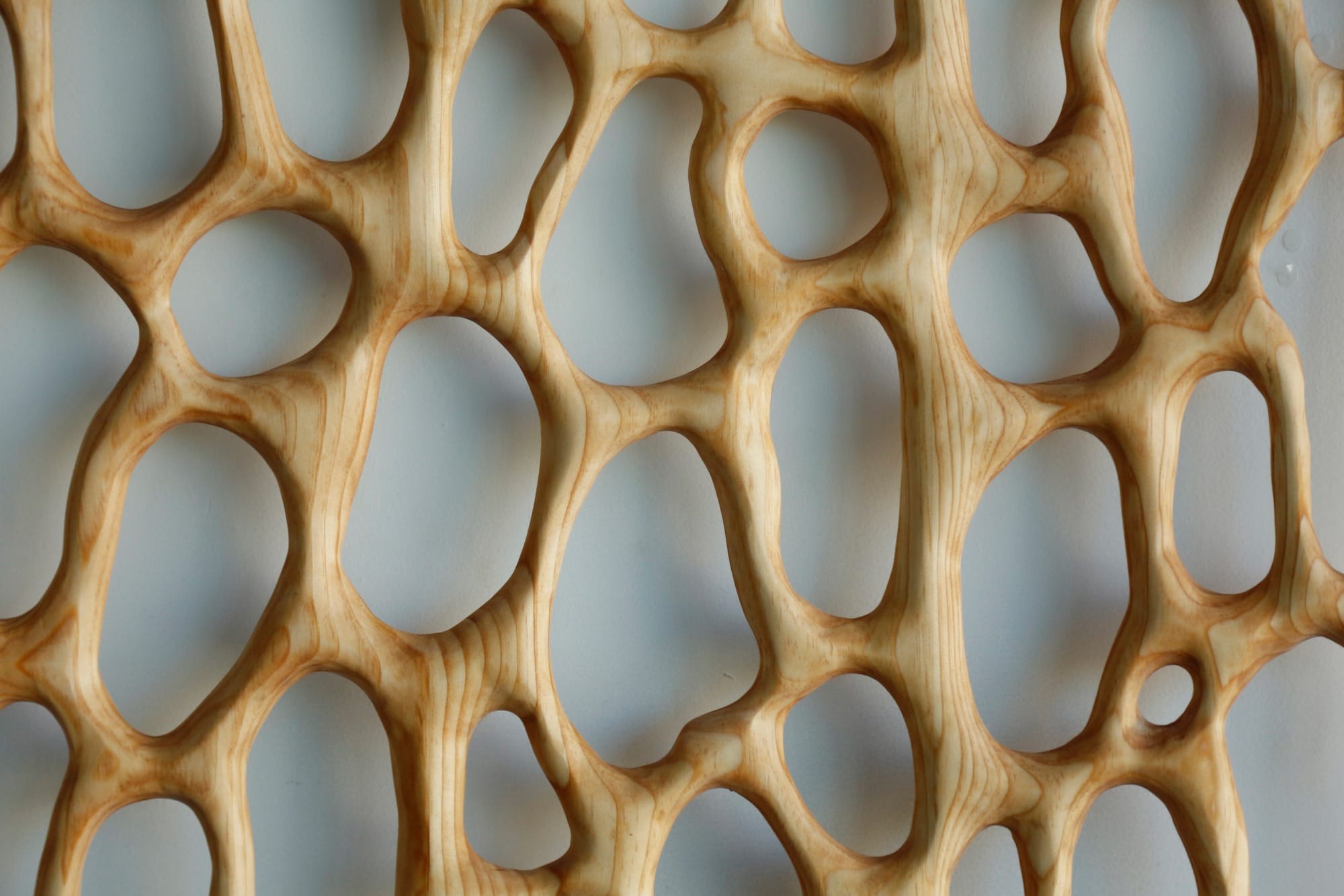 a detail image of a carved wood furniture piece with irregularly shaped holes