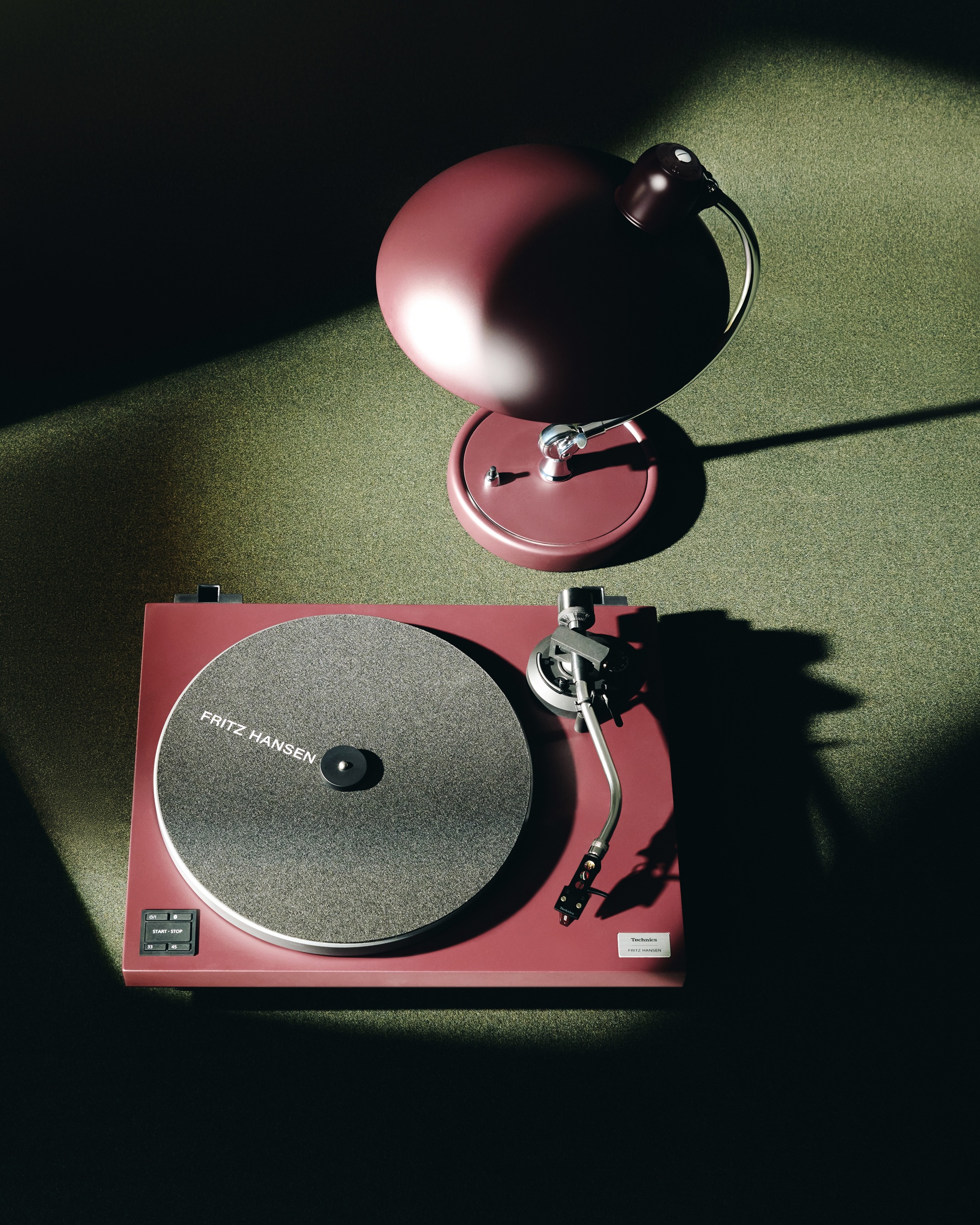 a turn table and lamp on a green surface