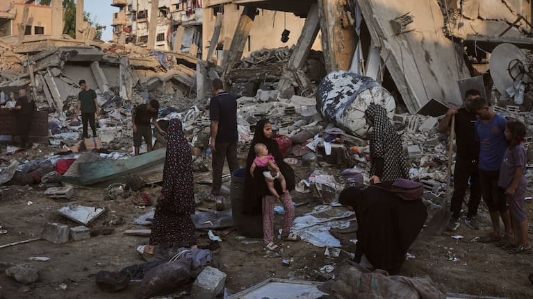 Palestinians salvage their belongings from the rubble of a building and tents destroyed in an Israeli airstrike in Gaza City.