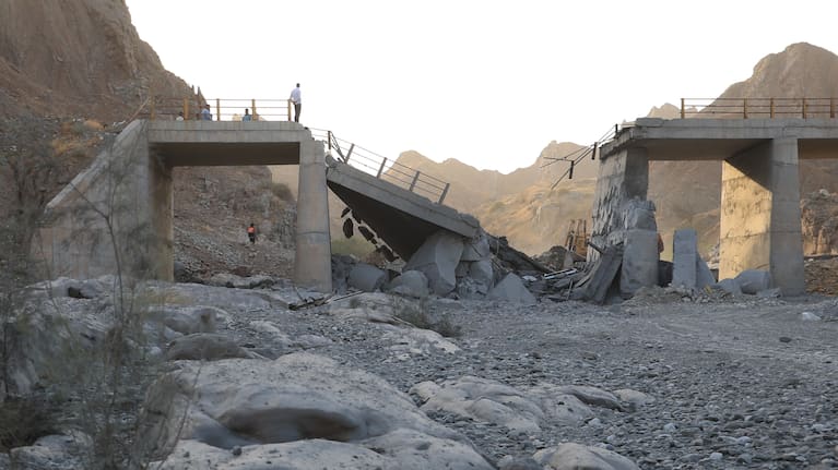 People stand on a bridge destroyed after a strike in Hormozgan province, southern Iran, Saturday, July 18, 2026.