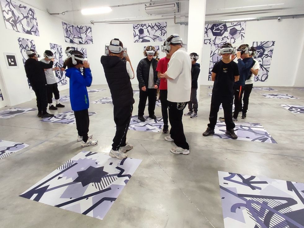 People wearing VR headsets in a gallery with abstract black and white art.