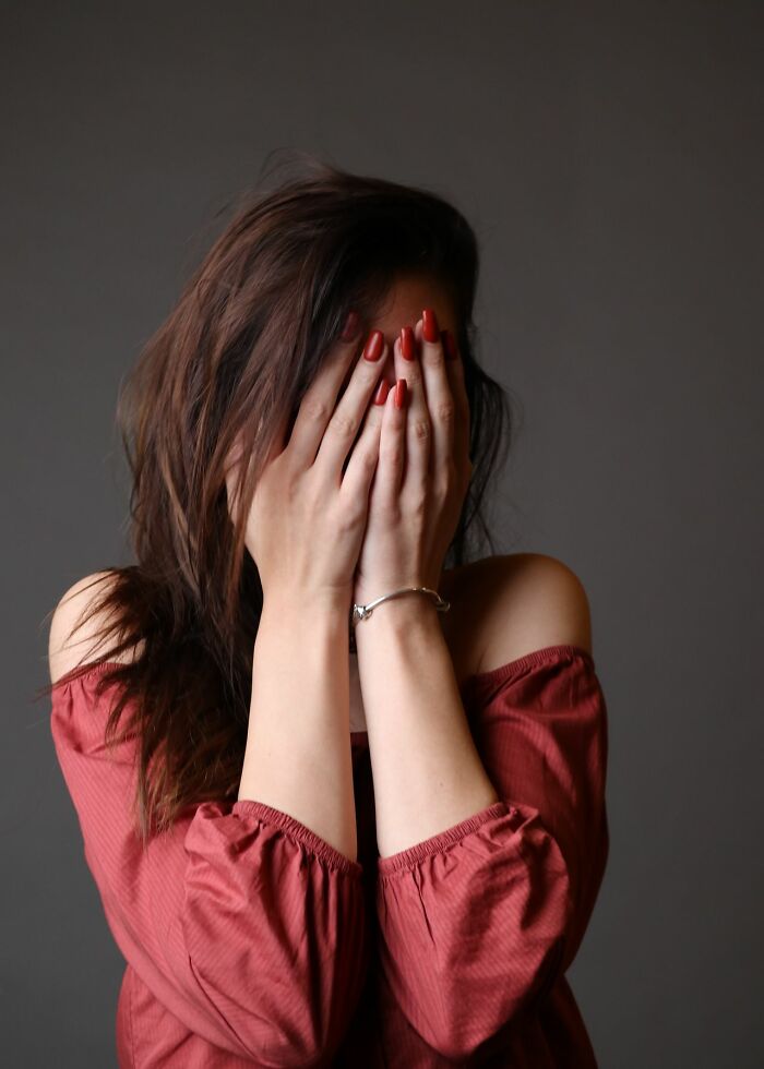 Patient covers her face, dealing with an embarrassing moment with ER staff.