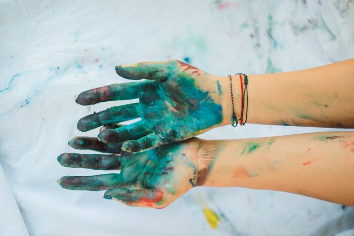 Hands covered in colorful paint, symbolizing a peculiar or messy situation ER staff might encounter with patients.