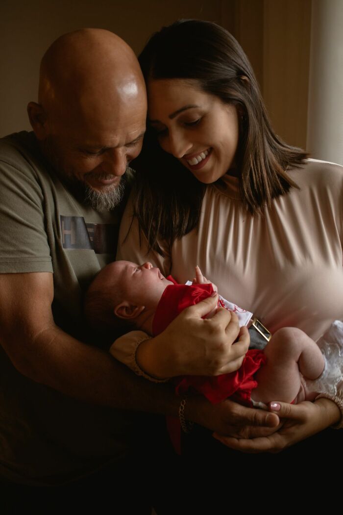 Happy parents holding their newborn baby, new patients in the healthcare system.